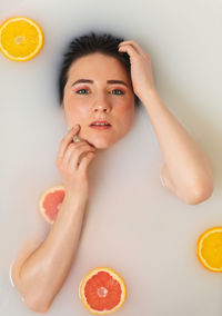 Portrait of young woman with fruits on table