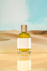 A plain perfume yellow liquid on a desert background