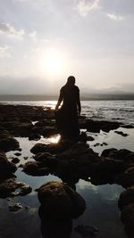 Rear view of silhouette man looking at sea against sky