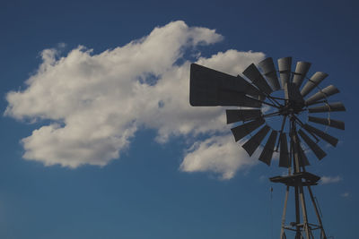 Low angle view of american-style windmill against blue sky