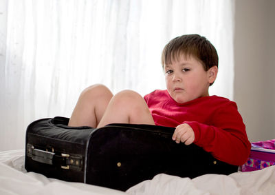 Boy sitting on bed at home
