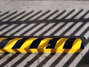 High angle view of yellow shadow on tiled floor