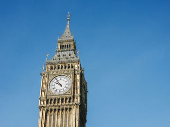 Low angle view of clock tower against clear blue sky