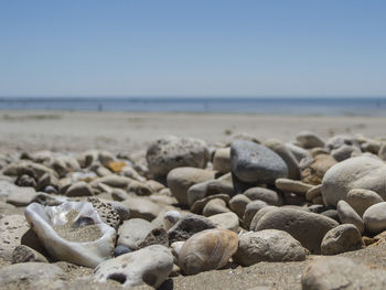 Close-up of pebbles on beach against clear sky