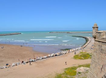 Scenic view of beach against clear blue sky