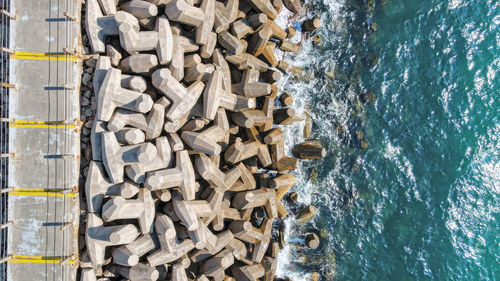 High angle view of stack of firewood by sea