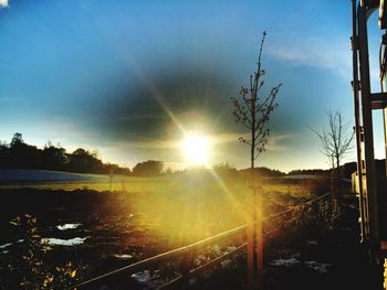 Scenic view of grassy field against sky at sunset