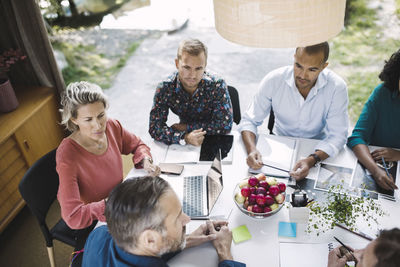 High angle view of business colleagues planning strategy at desk in portable office truck