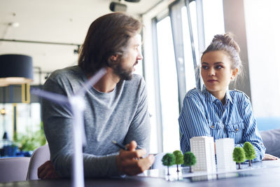 Business couple discussing over architectural model