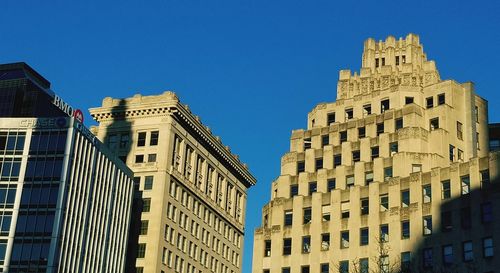 Low angle view of buildings against blue sky