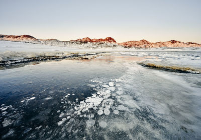 Coastline with ice and snow against rocks in winter