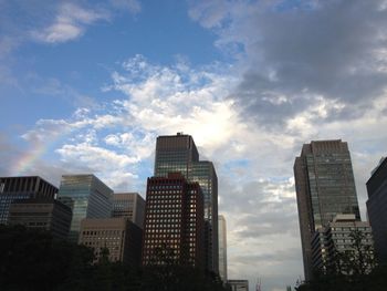 Low angle view of buildings against cloudy sky