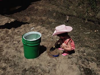 High angle view of girl playing at beach with shovel during sunny day