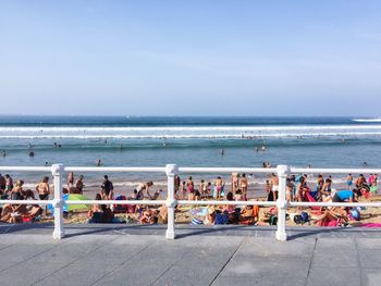 People enjoying at beach against sky