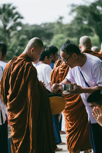 Rear view of people standing against temple