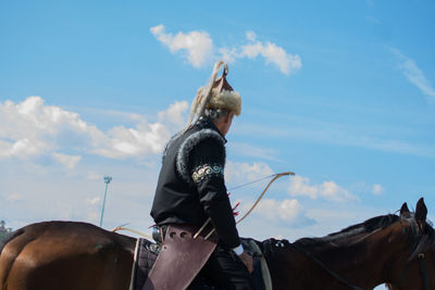 View of people riding horse against sky