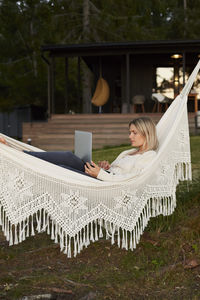 Woman using laptop on hammock