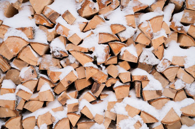 Textured firewood background chopped wood for kindling and heating. woodpile with stacked firewood