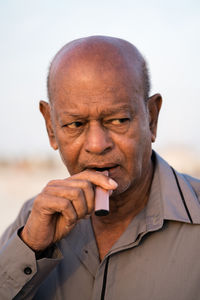 Portrait of senior man using vapour to smoke