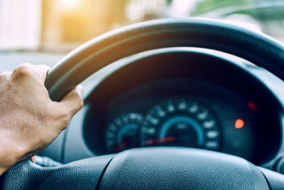 Cropped hand of man driving car