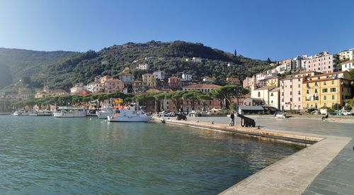 Houses by sea against clear sky