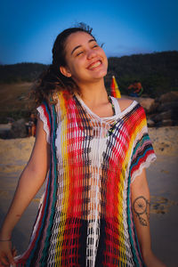 Portrait of a smiling young woman standing on beach