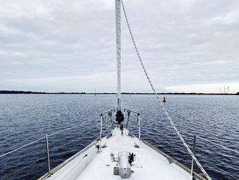 Sailboat sailing on sea against sky