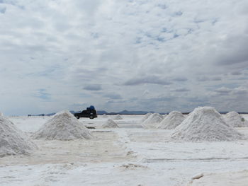 Heap of salt in salar de uyuni against sky