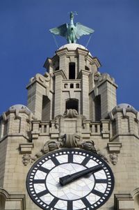 Low angle view of clock tower against building