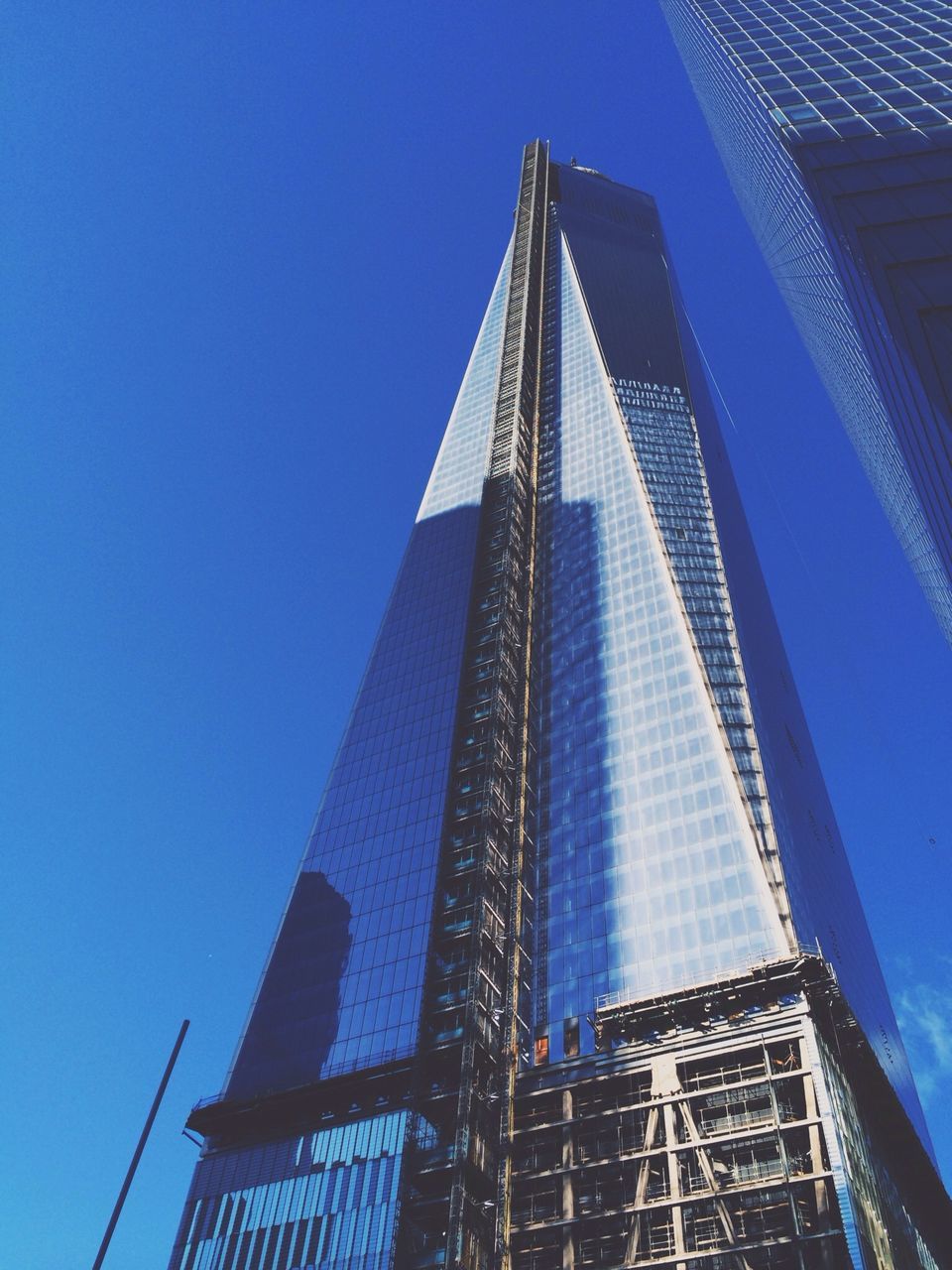 low angle view, architecture, built structure, building exterior, blue, modern, tall - high, skyscraper, tower, office building, city, clear sky, building, sky, outdoors, day, no people, sunlight, tall, glass - material