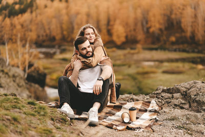 Portrait of young couple sitting outdoors