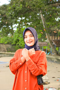 Portrait of smiling young woman standing outdoors