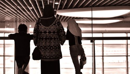 Rear view of people standing on escalator