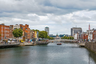 River amidst buildings in city against sky