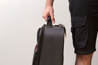 Midsection of man holding camera against white background