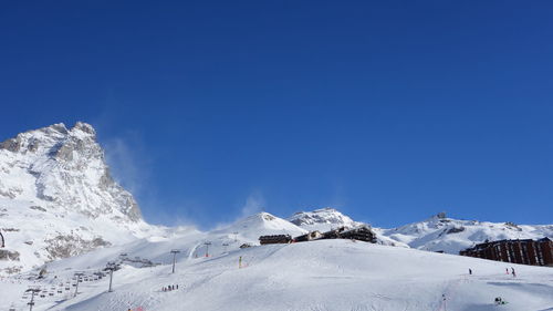 Scenic view of snowcapped mountains against clear blue sky