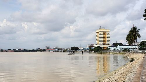 Buildings by sea against sky