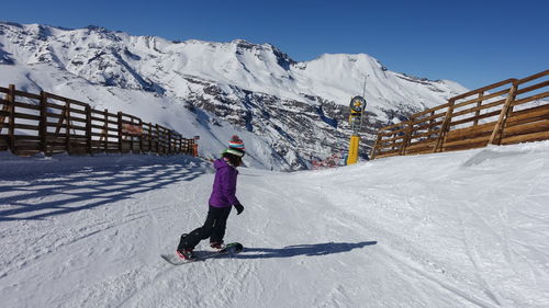 Full length of person skiing on snowcapped mountain against sky