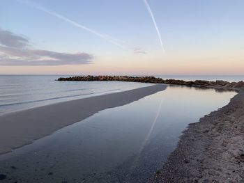 Scenic view of beach against sky during sunset