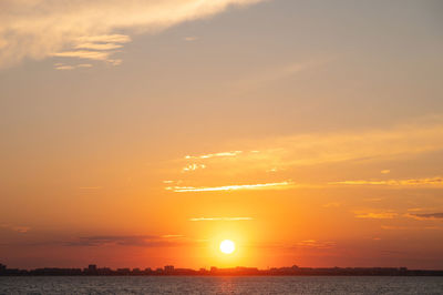 Evening landscape sunset over the lake. round large sun over the horizon. sunset sky with clouds 