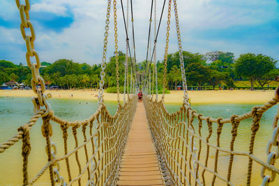 Rear view of man walking on footbridge