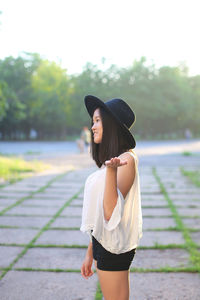 Full length of woman standing on footpath