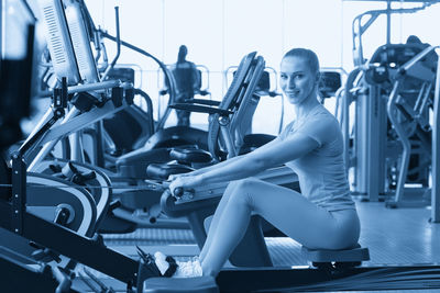Side view of woman exercising in gym