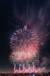 Firework display over sea at night