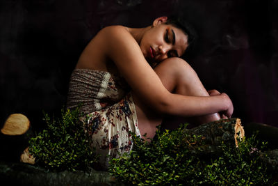 Portrait of young woman sitting on field