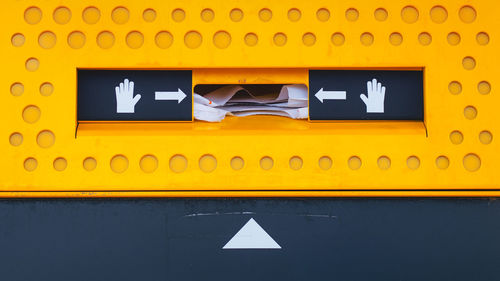 Low angle view of yellow sign on wall