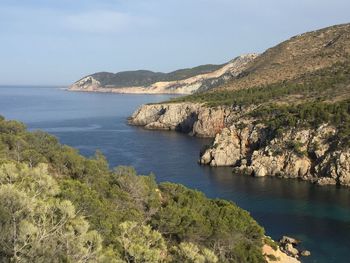 Scenic view of sea and mountains against sky