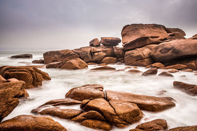 Rocks on beach against sky