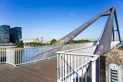 Bridge over city buildings against clear blue sky