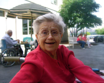 Portrait of smiling senior woman sitting outdoors